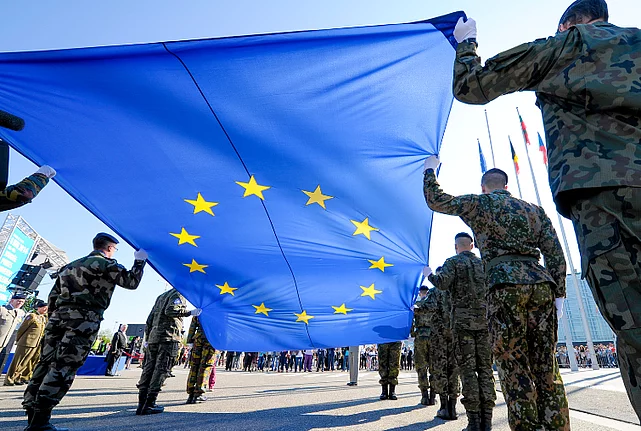 Soldiers from EU countries carrying the EU flag.