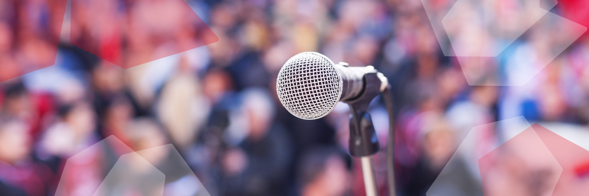 A microphone in front of a blurry crowd.