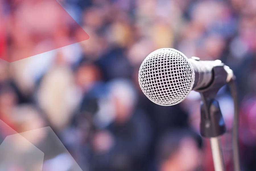 A microphone in front of a blurry crowd.
