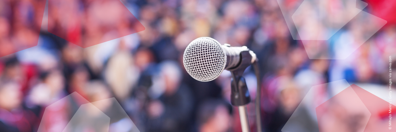 A microphone in front of a blurry crowd.