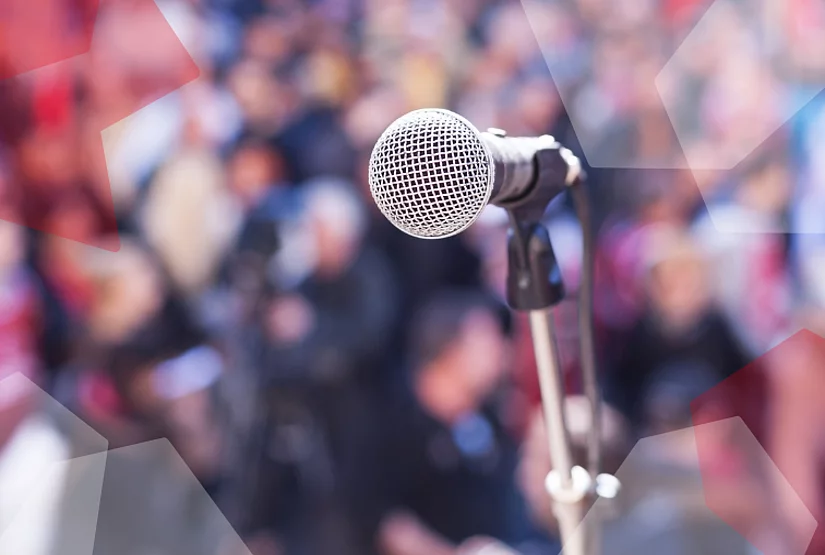 A microphone in front of a blurry crowd.