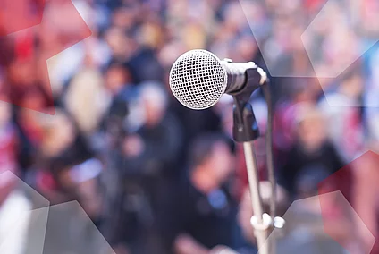 A microphone in front of a blurry crowd.