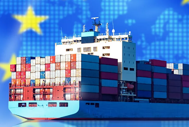 A cargo ship with an EU flag in the background.