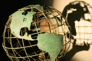 A model of a globe casting a shadow on the wall behind it.