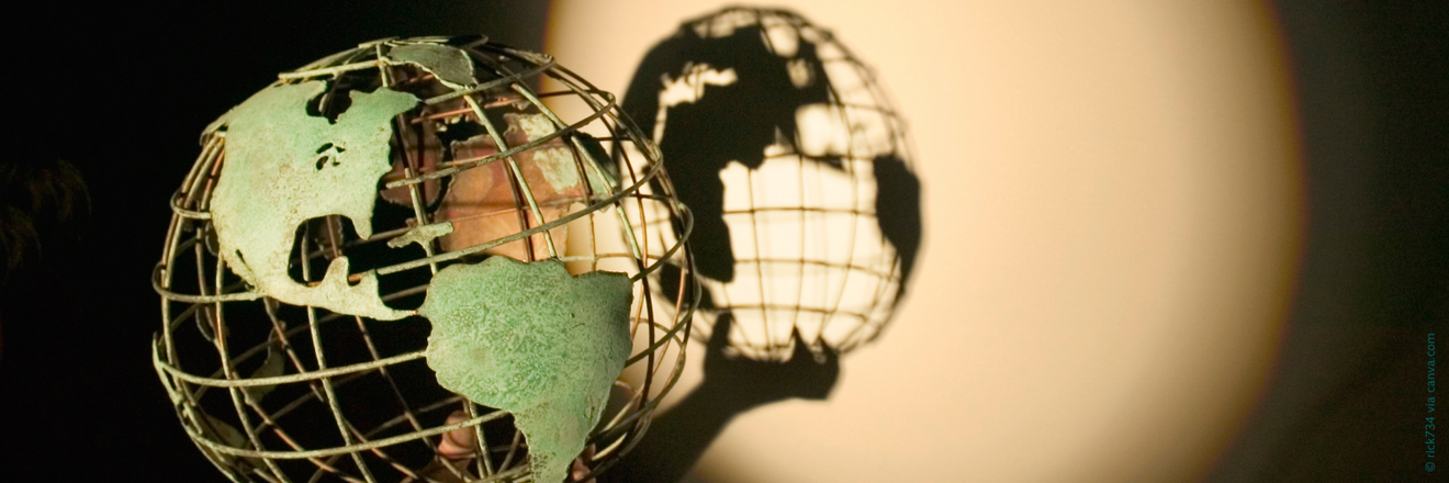 A model of a globe casting a shadow on the wall behind it.