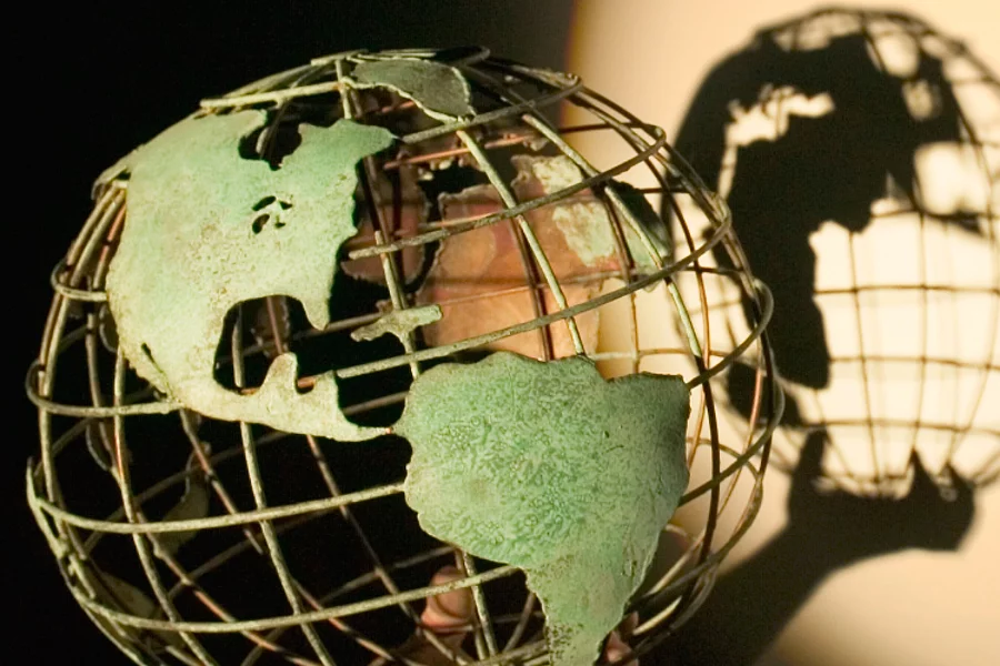 A model of a globe casting a shadow on the wall behind it.