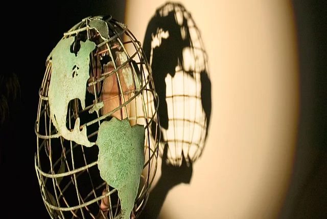 A model of a globe casting a shadow to the wall behind it.